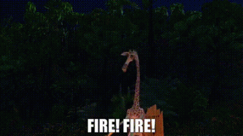 a firefighter's giraffe is silhouetted against trees in the dark