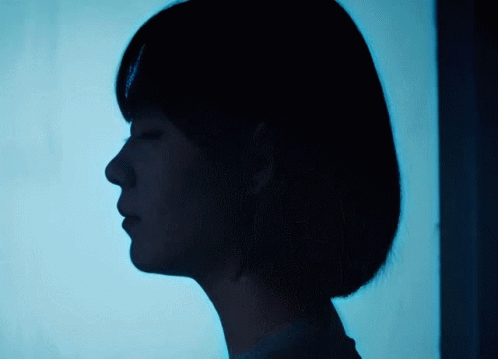 a profile s of a woman's face, with the sun coming through the curtain behind her