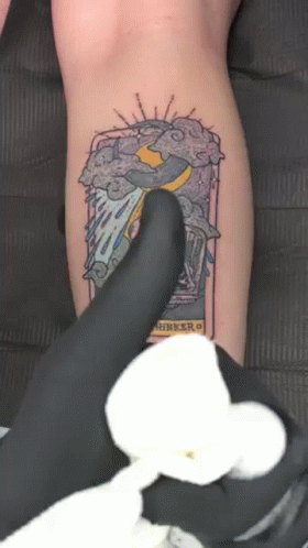 an arm with a tattoo on it next to a foot with a hand
