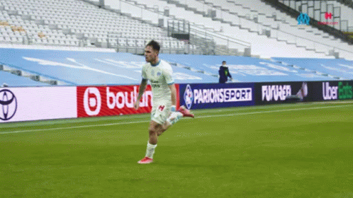 a man kicking a soccer ball on top of a field