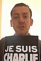 a man holds a sign with je sous charlie on it