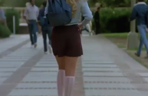 a girl is walking in shorts and boots