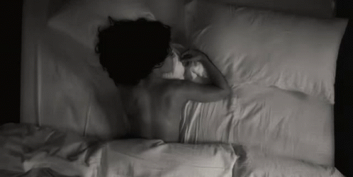 black and white pograph of a person sleeping in bed