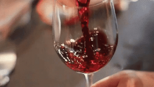 a blue substance being poured into a wine glass