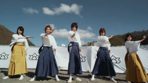 three women wearing long skirts pose for a po