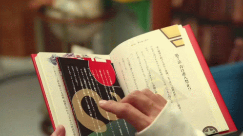 the hand is holding the book open to read