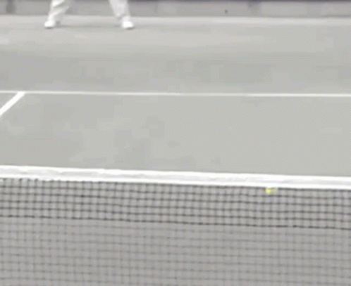 a man standing on a tennis court holding a racquet