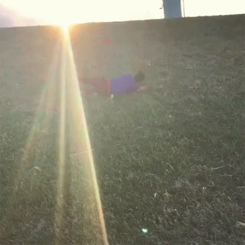 an image of a boy laying on the ground on a grassy field