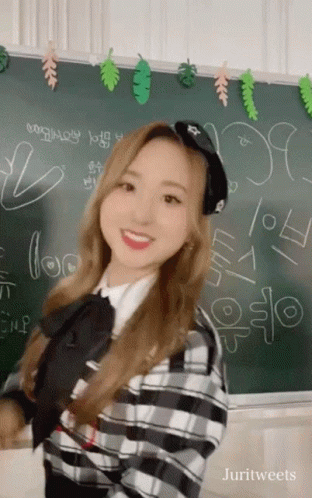 a picture of a girl standing in front of a chalkboard