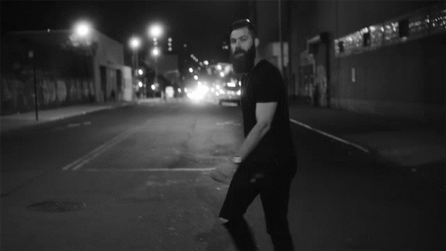 a man with a beard walking down a street