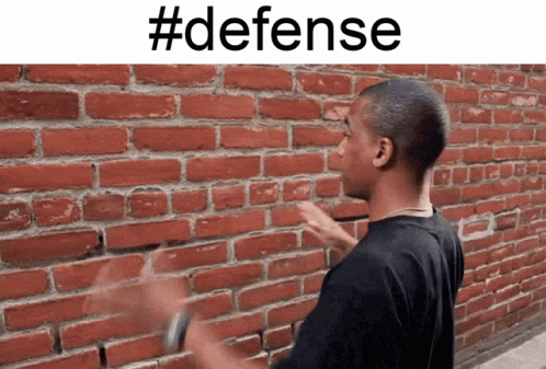a man points at the wall that reads defense