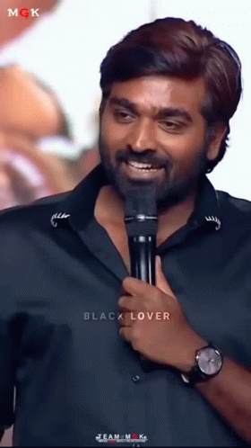 actor karaindu ravian smiling while holding a microphone
