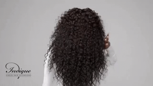 an up close image of a curly haired women