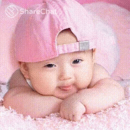 a small child wearing a purple hat in the middle of a bed