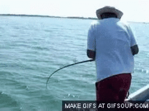 man holding a fishing rod and hooked up to a boat in the ocean