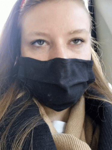 a lady in a sweater with a face mask