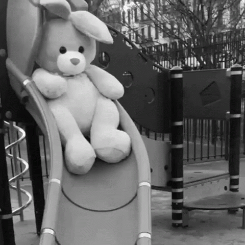 stuffed animal sitting on slide on park play structure