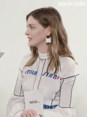 a woman wearing earrings with writing on her shirt