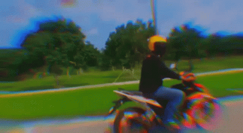 a person on a motorbike riding with a camera and filter applied to the image