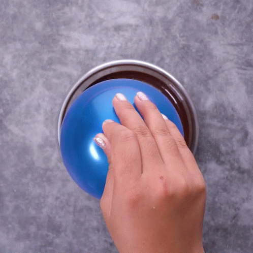 a hand reaching to touch an orange disc