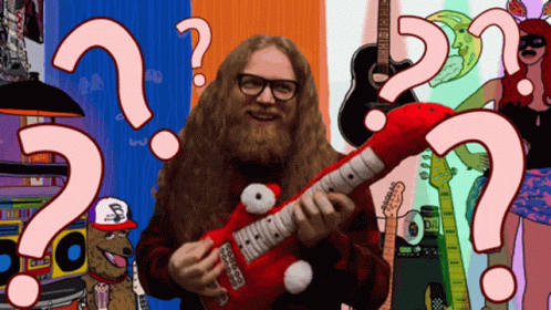 a man with a long beard plays an electric guitar with question marks painted on it