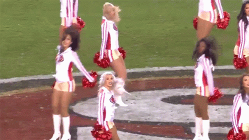 cheerleaders in cheer uniforms perform on the field