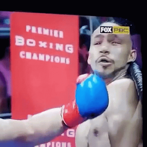 a shirtless man wearing boxing gloves on a television screen