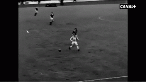 a soccer player running toward the ball that was thrown to him