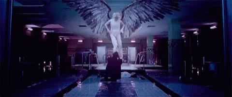 a large angel statue is in a long hallway