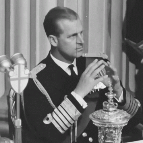 a boy sitting in front of a trophy wearing an uniform