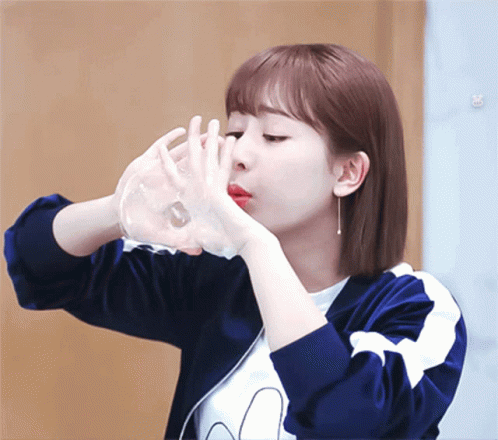 a asian girl in brown and white shirt holding her hands over her face