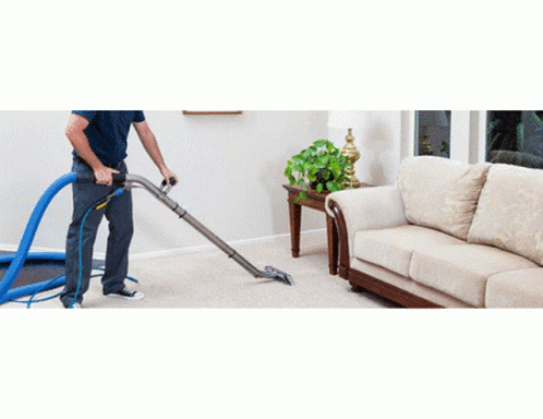a person vacuum cleaning a carpet with a large floor cleaning machine