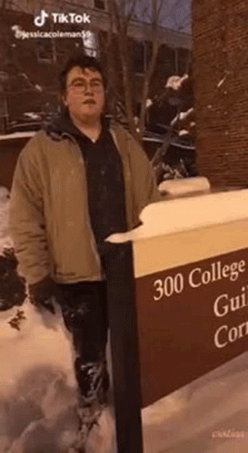 man standing in front of a sign that says 300 college and university cam