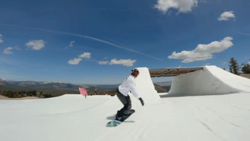 a snowboarder is going down the slope on a sunny day