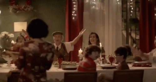 a woman waves at her family in a crowded dining room