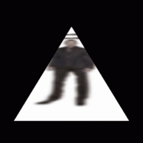 a man in black and white stands inside a white triangle