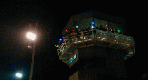 the view shows a night scene of some people on a tower