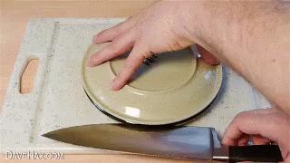 a gloved hand is removing a plate from a  board