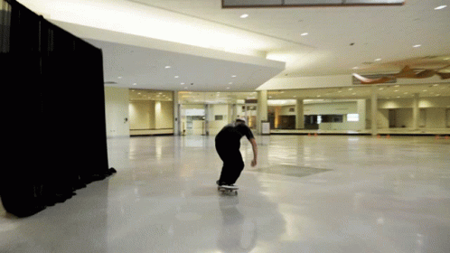 a person on a skateboard in the middle of a large room