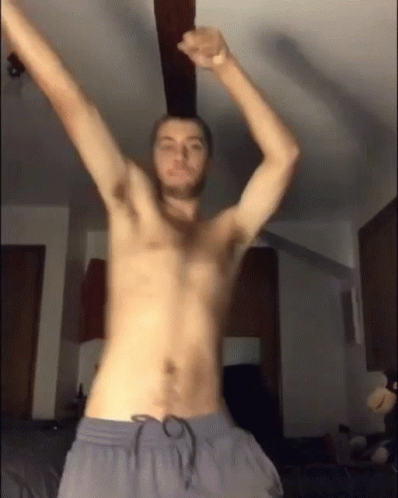 a man is shirtless and has his arms in the air