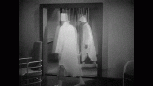 black and white image of man walking through door