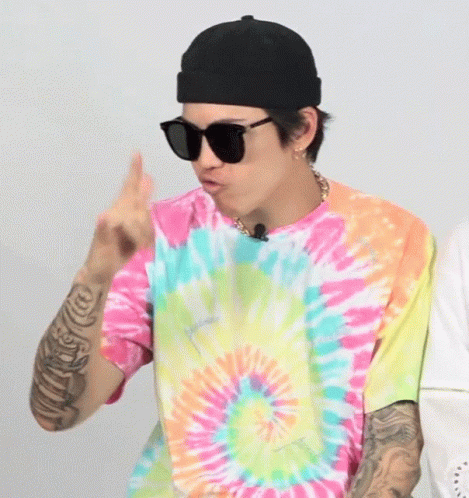 a person wearing sunglasses and tie dyed shirt