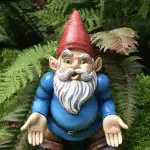 a toy gnome sits on top of grass