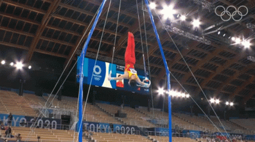 an olympic gymnastics event during a darkened stadium