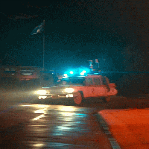 a police truck with its lights on and an emergency vehicle behind it