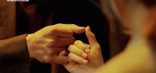 a man and woman holding hands while touching noses