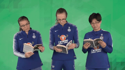 three soccer players wearing orange are reading a book