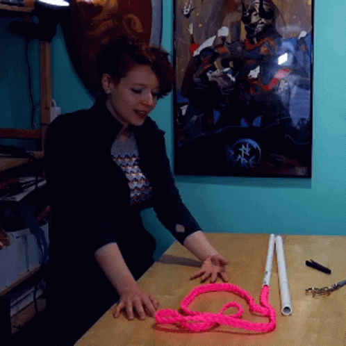 a woman making a piece of string in a room