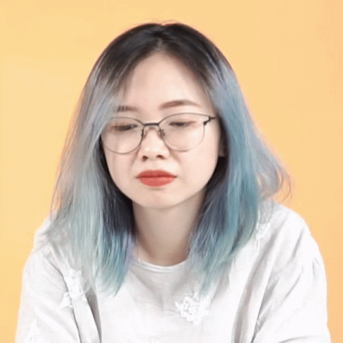 a woman with glasses and blue lips sitting down