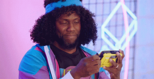 a young man with an afro and yellow hat holding a phone